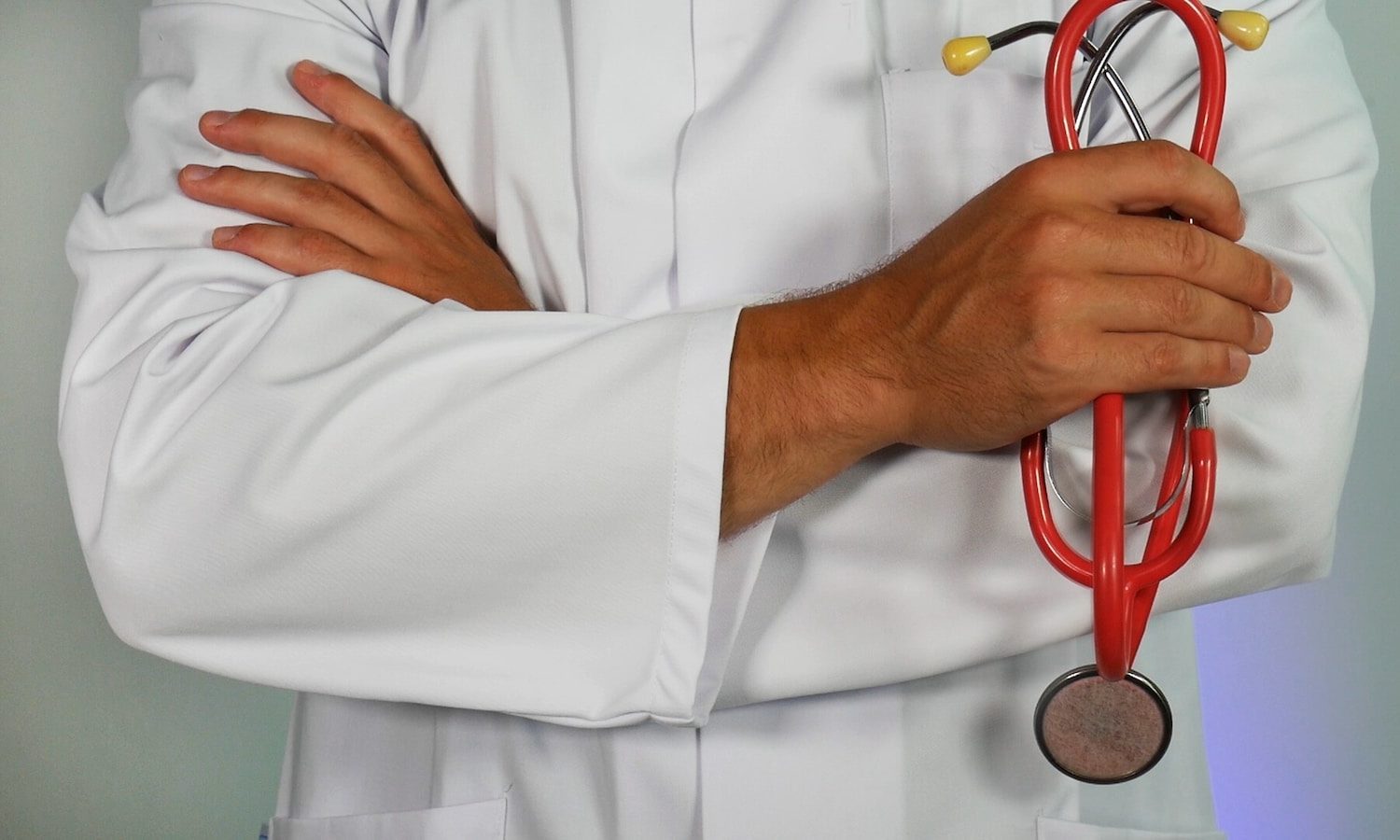 läkare håller rött stetoskop